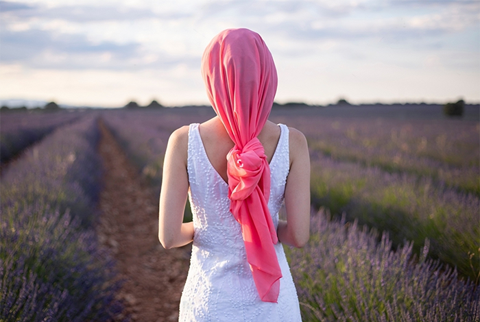 Woman with pink cancer scarf in a lavender field