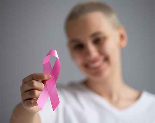 Young woman with pink ribbon on a white background. Mammary cancer
